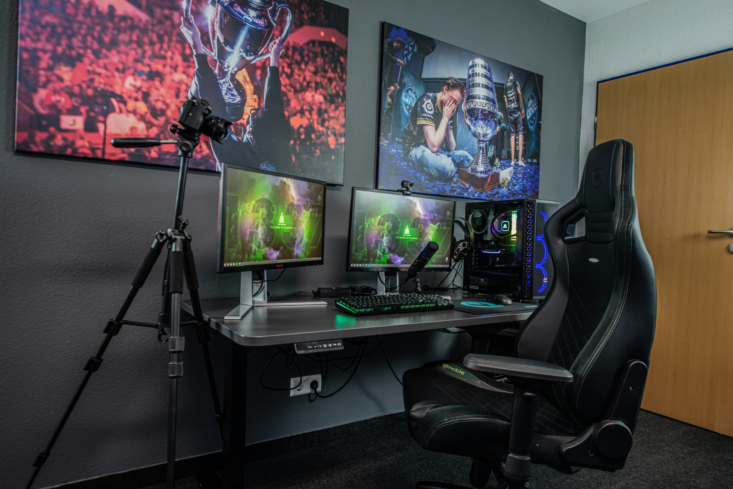 Gaming chair at a desk with dual monitors RGB keyboard and gaming PC in a dark gaming room setup