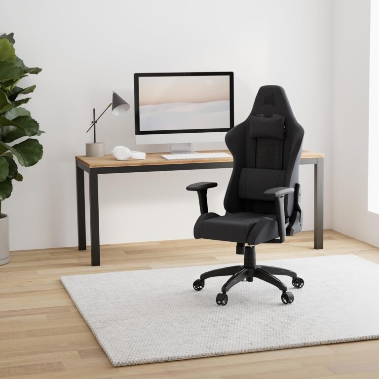 Corsair TC100 Relaxed gaming chair in black fabric shown in a clean home office setup with desk and monitor